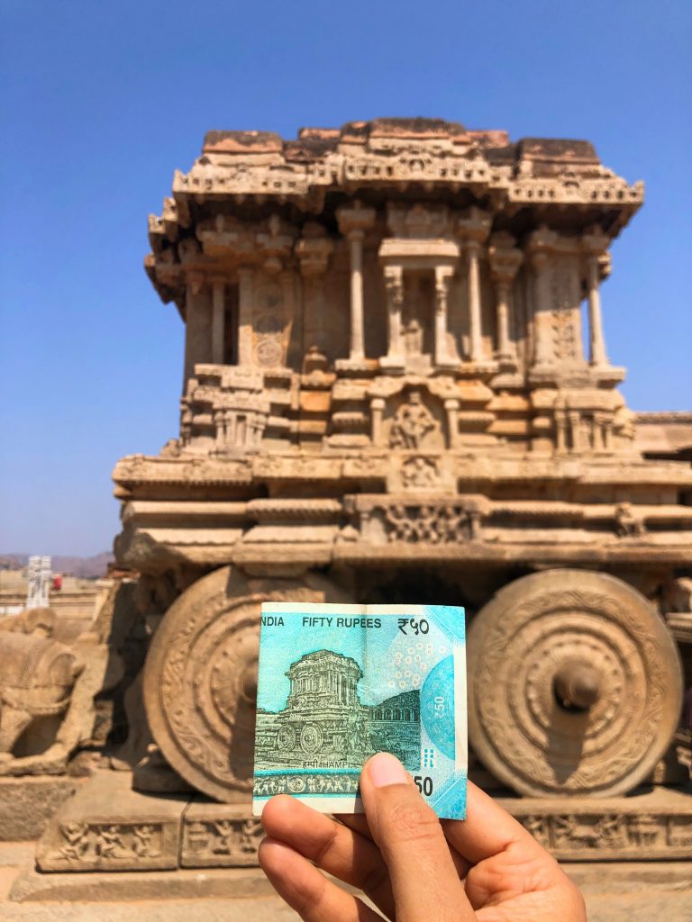 A picture of a 50 rupee note against an ancient site